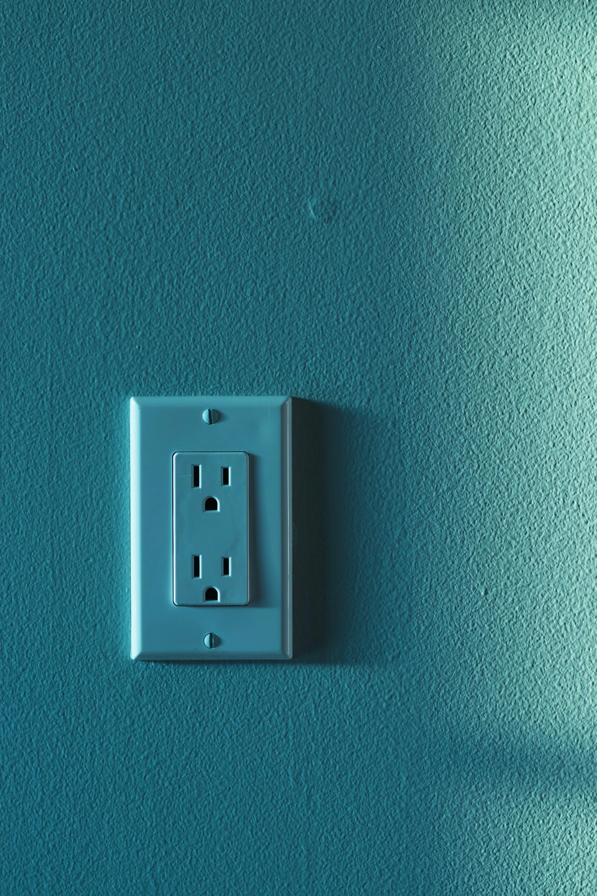 Wall outlet on a teal painted wall