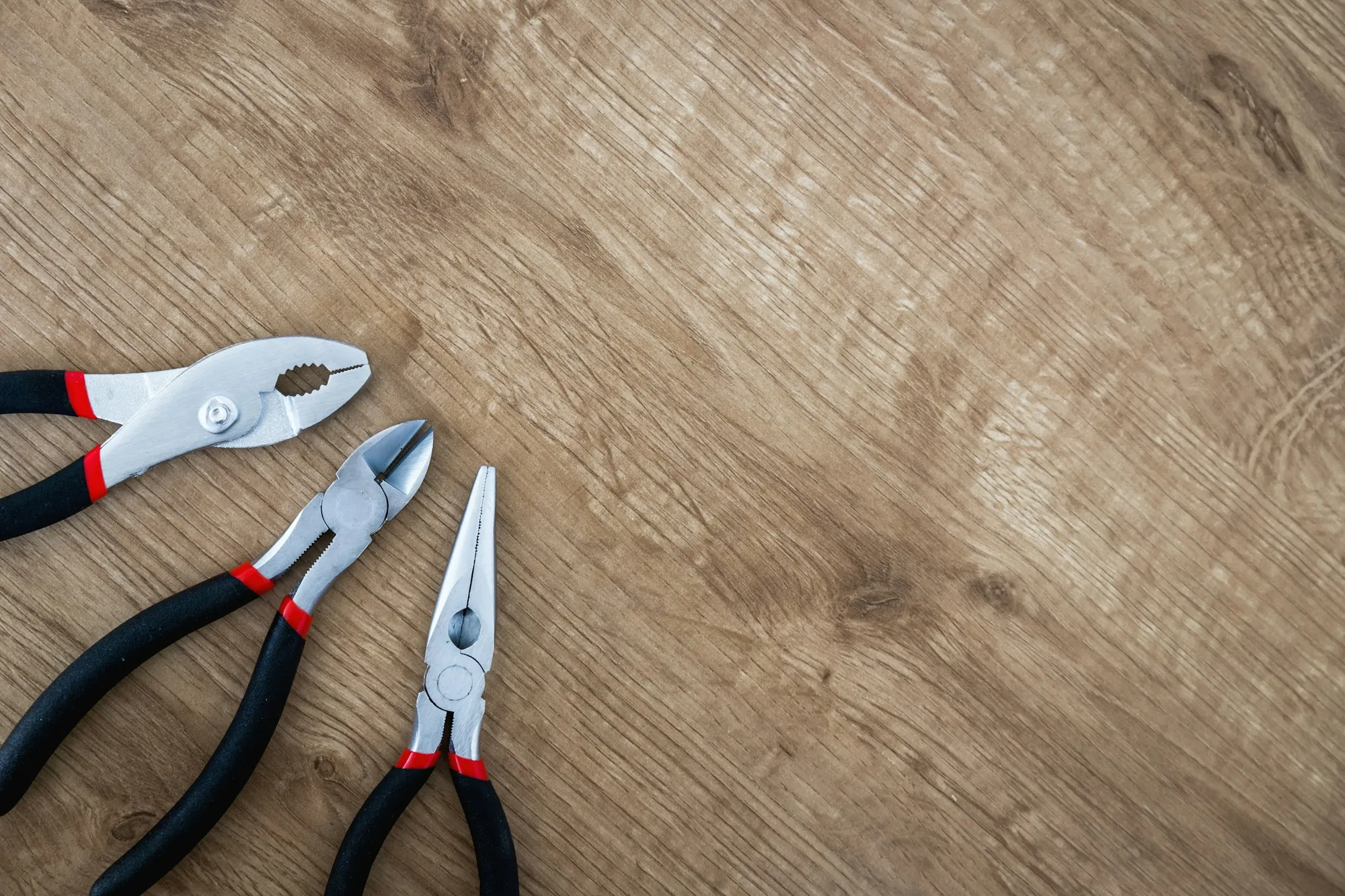 Pliers and side cutters on a wooden bench