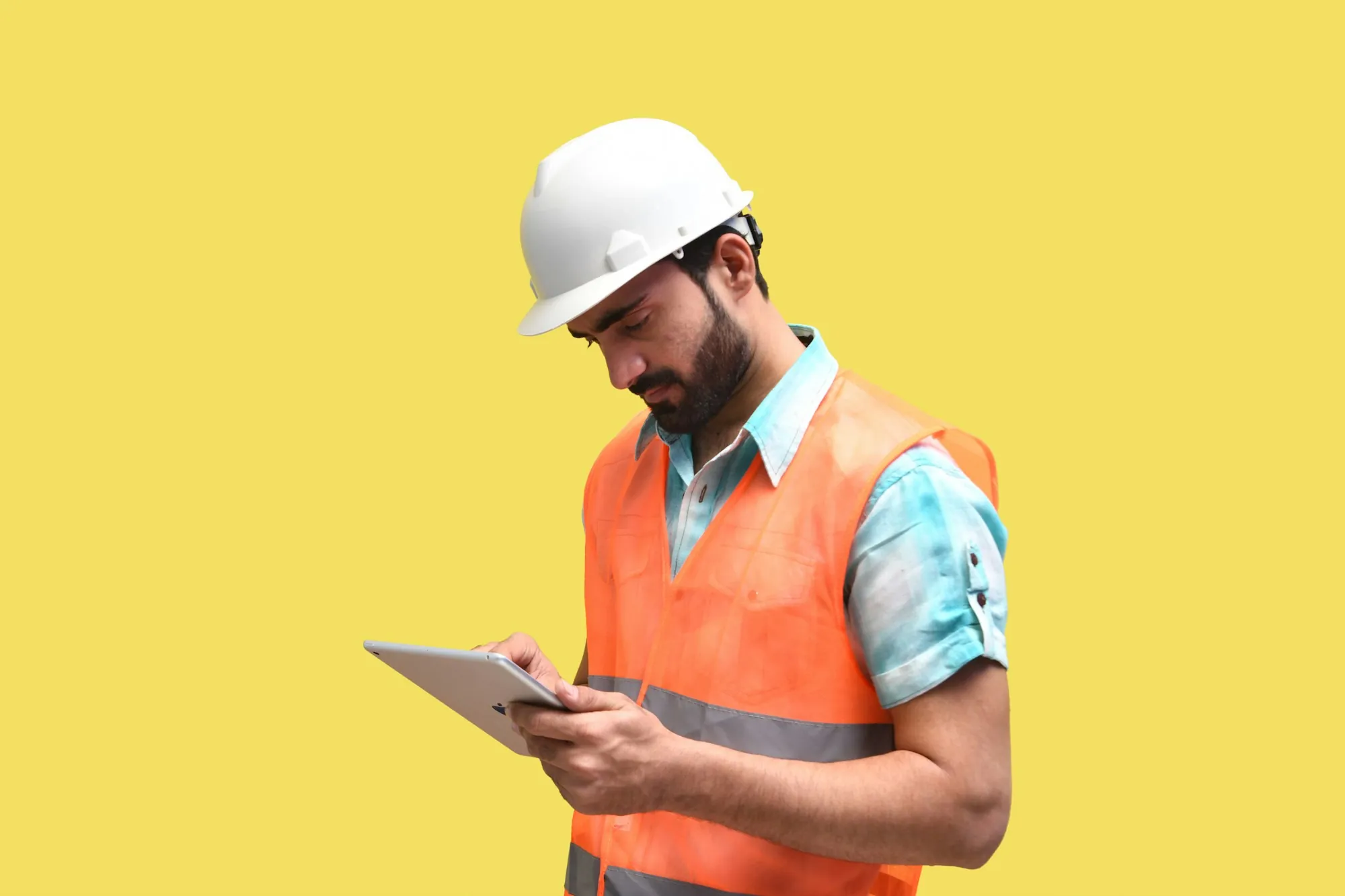 Electrician in a hard hat reviewing a job on a tablet
