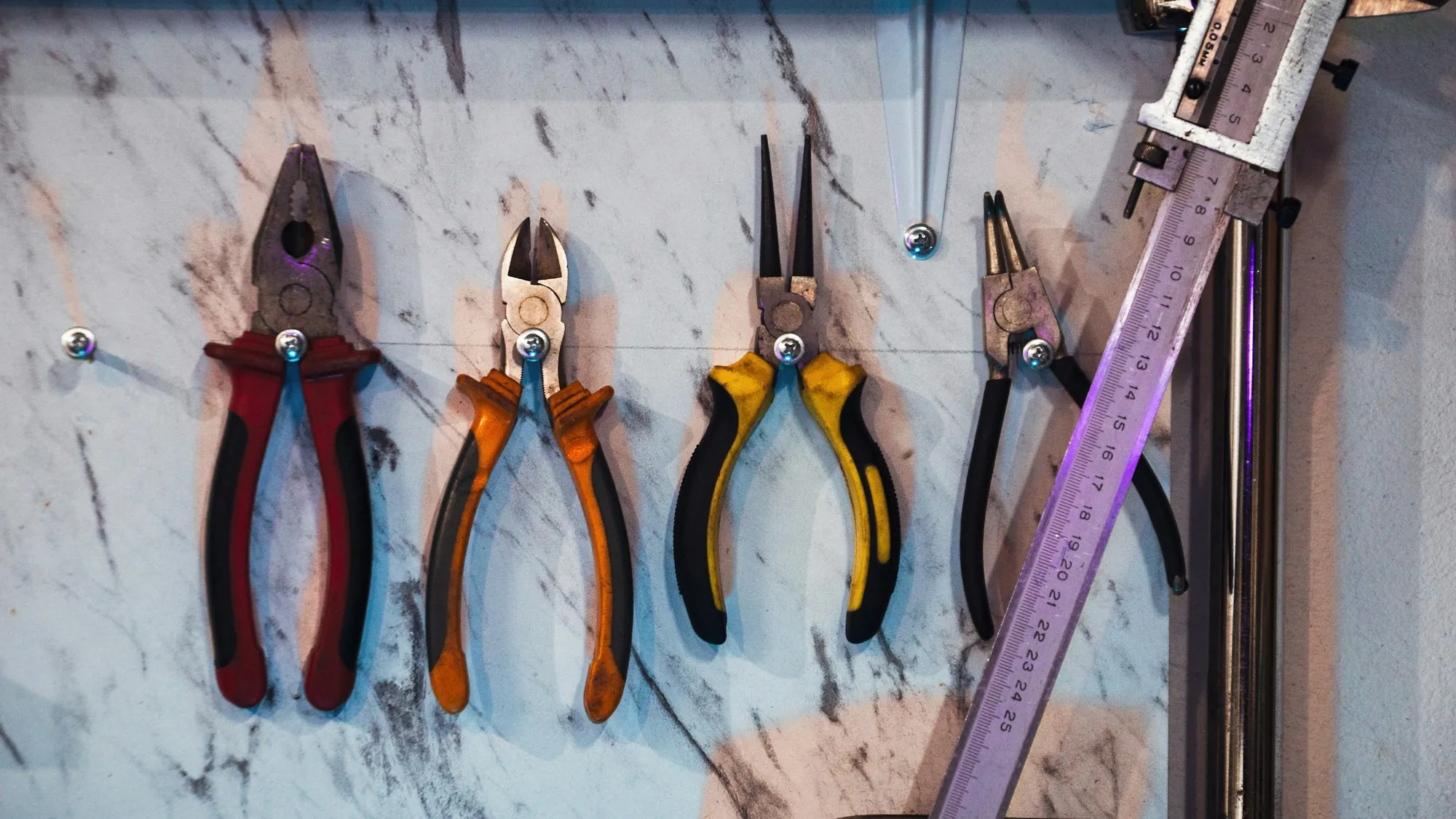 Pliers and hand tools hanging on a workshop wall